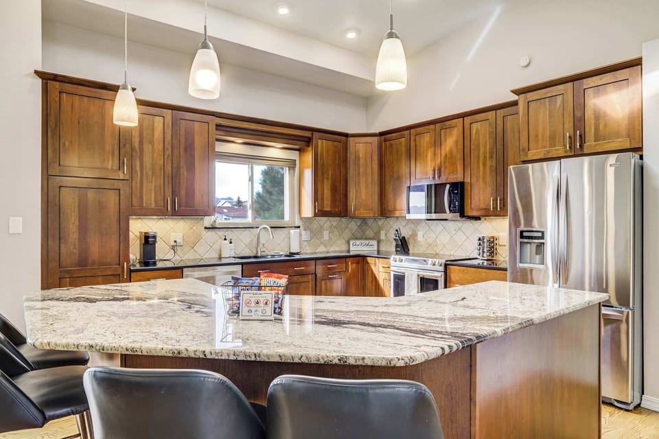 Prepare home-cooked meals in this fully stocked kitchen featuring high-end stainless steel appliances. The expansive wrap-around counters and generous cabinet storage ensure you have everything needed for a premium culinary experience.