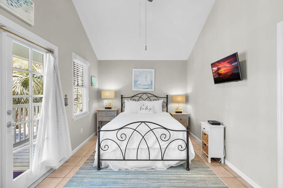Guest bedroom with bedside lighting and vaulted ceiling