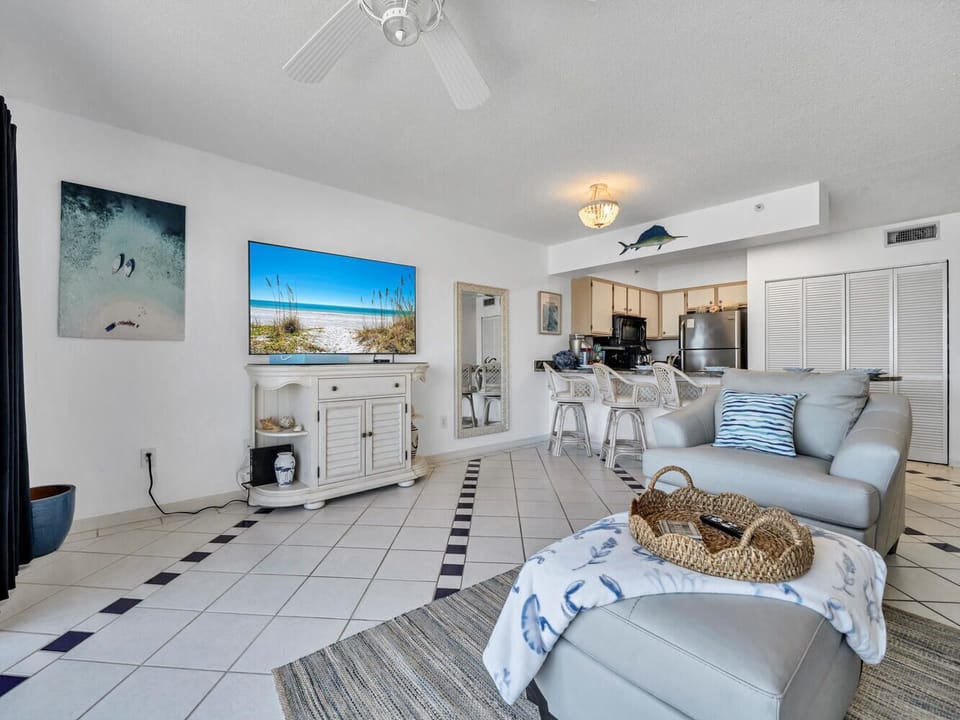 Relax in your coastal-themed living space with plush seating and an open kitchen perfect for beach getaway meals.