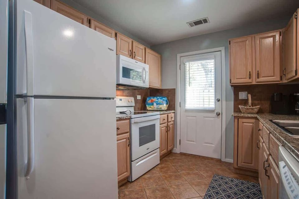 Your fully equipped kitchen features modern appliances and warm wood cabinets, perfect for preparing meals during your stay.