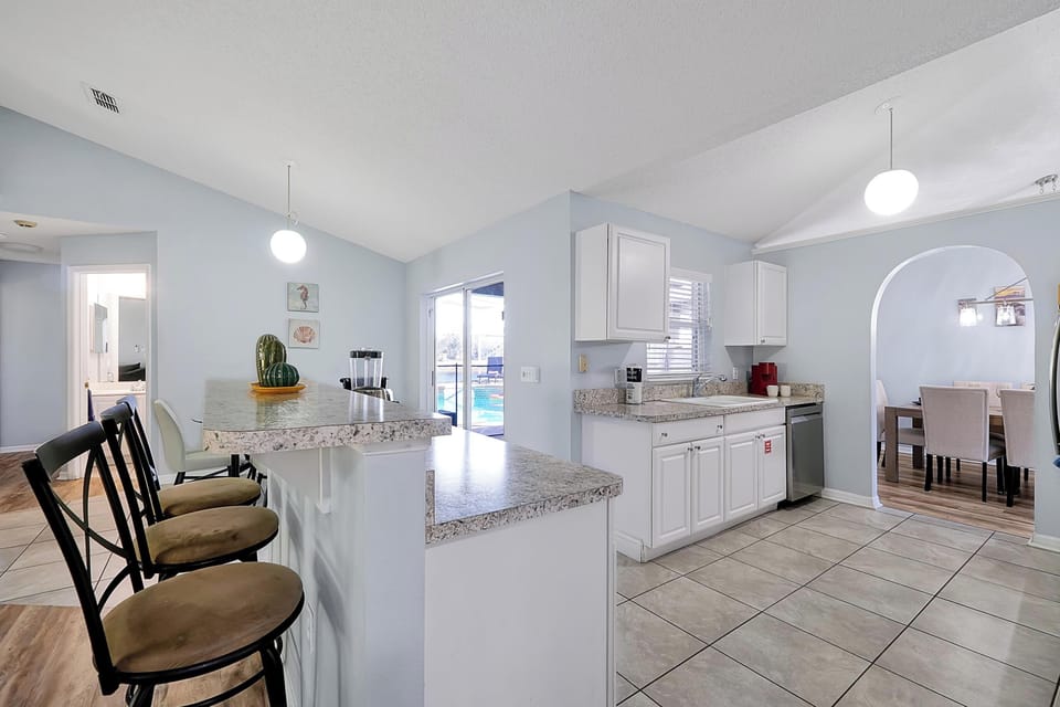 This bright kitchen features a spacious breakfast bar and overlooks the pool deck.