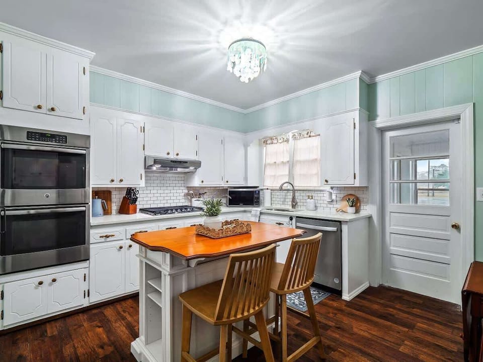 Clean kitchen w/ white cabinetry & island for prep & casual dining