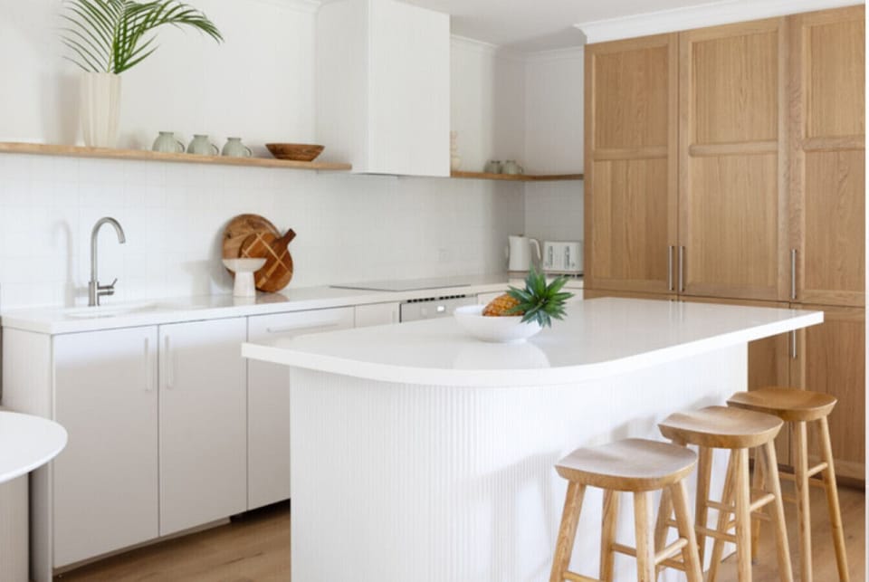 A white curved stone bench highlights the kitchen.