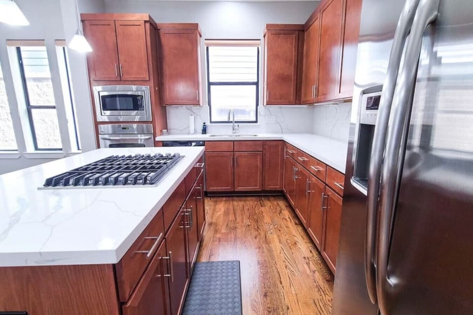 Fully equipped kitchen stocked with cooking utensils, silverware, dinnerware, and cookware.