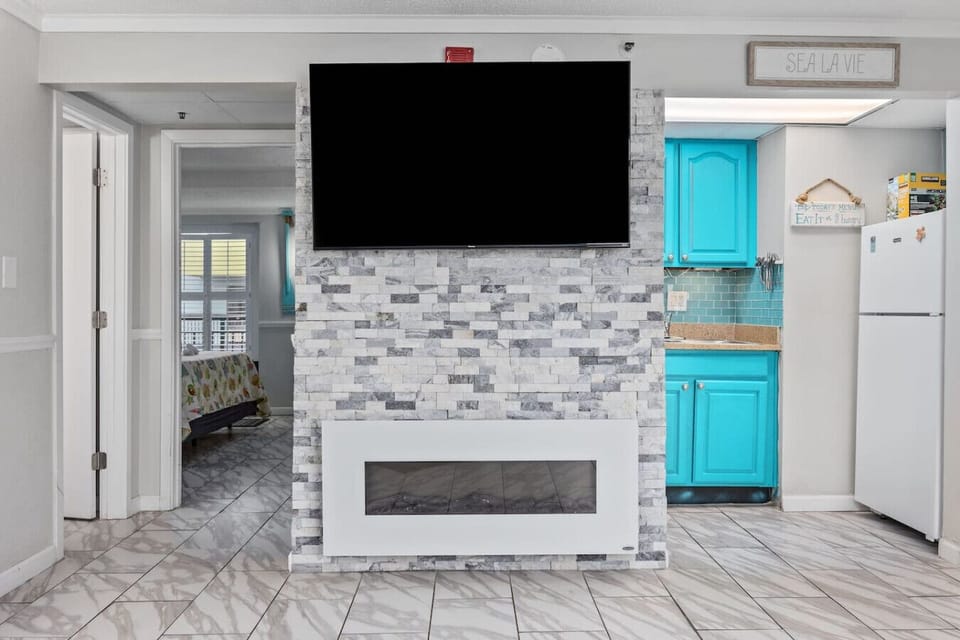 Stylish stone fireplace paired with a big-screen smart TV creates a cozy, inviting living space.