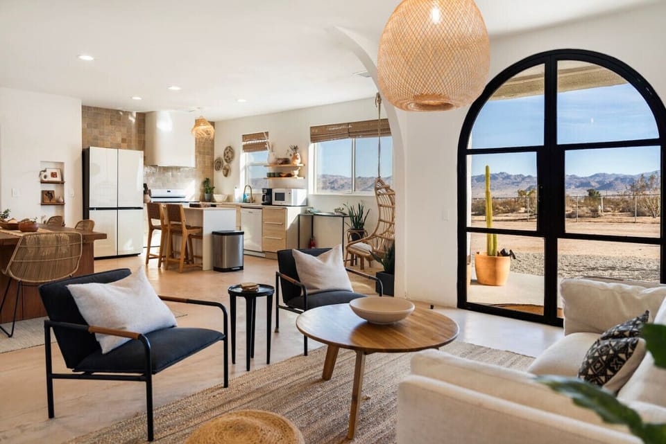 Bright, airy, and desert-framed. Modern interiors with a Joshua Tree view right through the arch window.