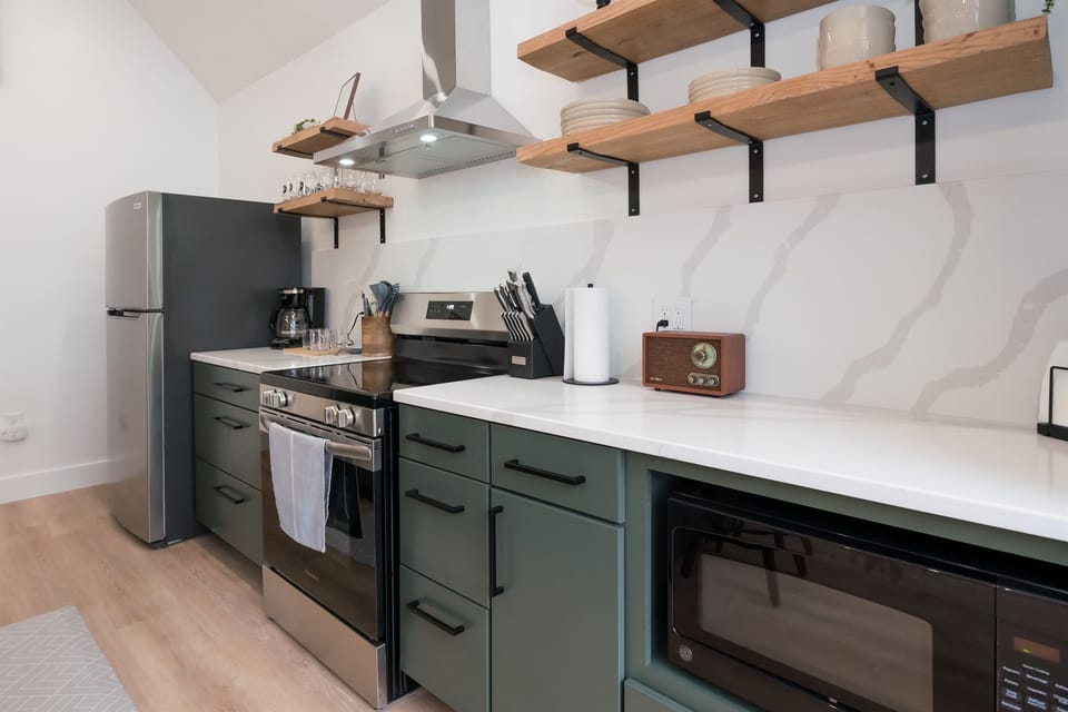 Kitchen at Hemingway — dark cabinetry, open shelving, full-size appliances, counter space for meal prep