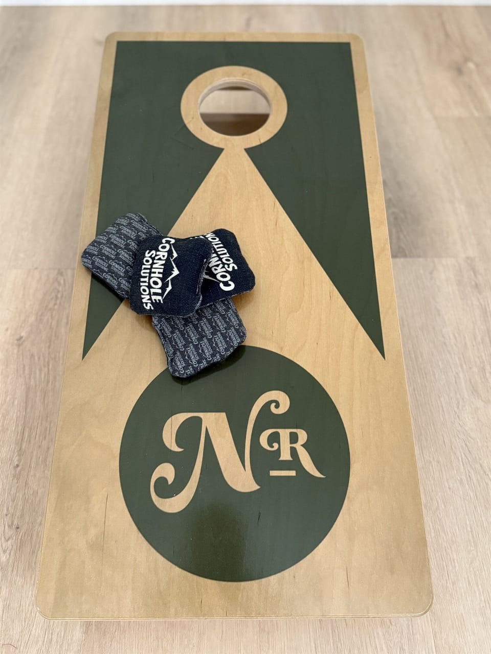 Indoor cornhole in the shared game room — separate building a short walk from Hughes, open to all Notestone Reserve guests