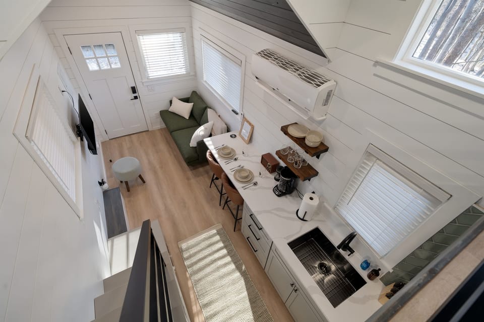 Main floor overview from above at Hughes — open layout, lofted bed visible above, living area below