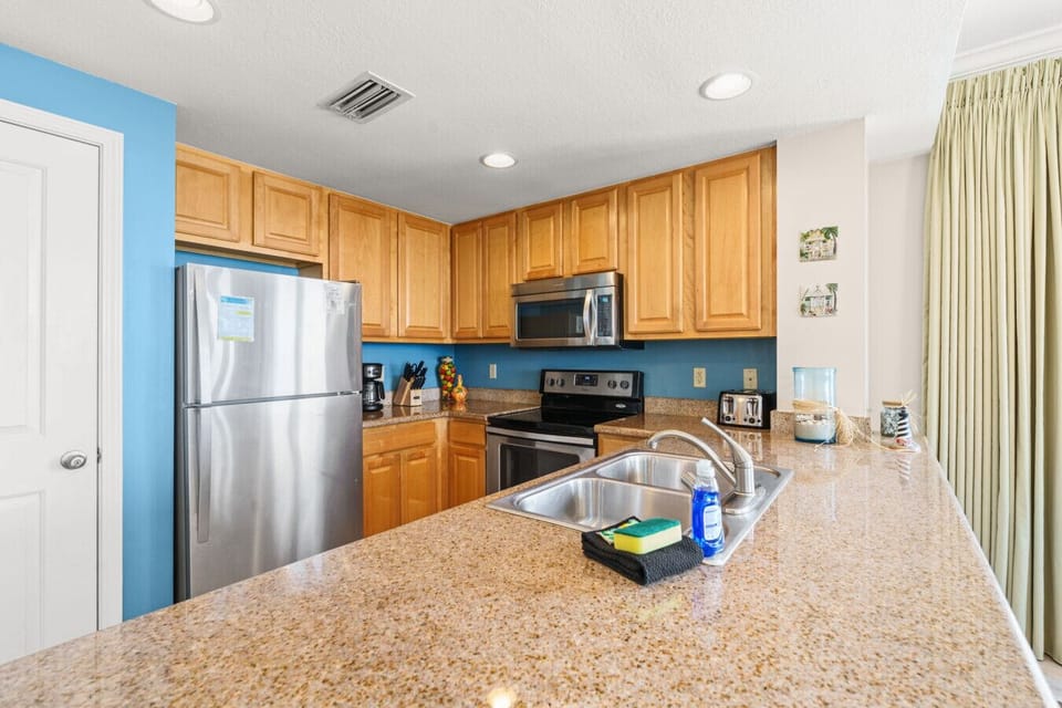 Whip up delicious meals in the fully equipped kitchen featuring granite countertops, stainless steel appliances, and coastal touches.