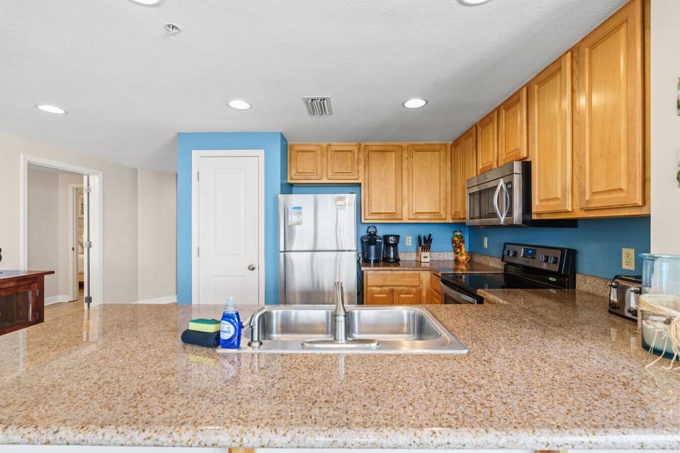 Whip up delicious meals in the fully equipped kitchen featuring granite countertops, stainless steel appliances, and coastal touches.