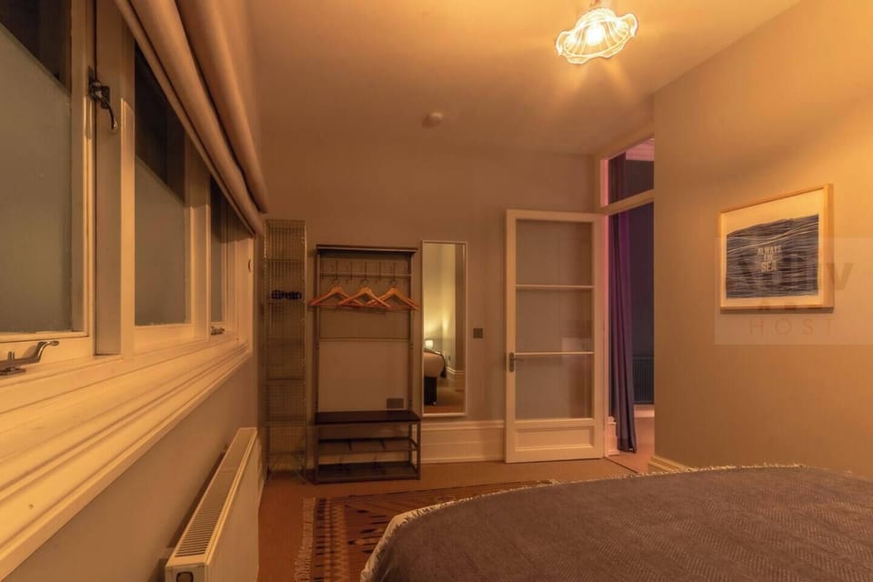 A tranquil and impeccably styled guest bedroom where soft, neutral tones and refined period details create a peaceful sanctuary for a restful night’s sleep.