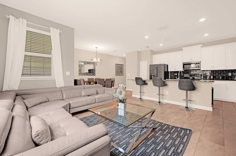 Relax in this stylish open-plan living area with a modern kitchen and ample seating, perfect for gatherings.