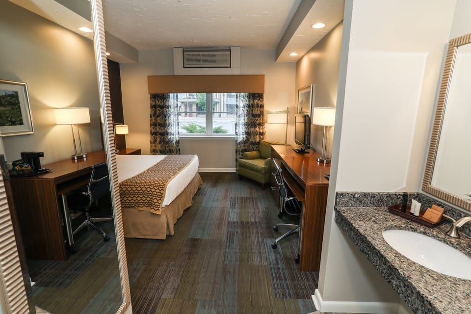 Well-appointed room featuring a cozy bed, seating area, and convenient workspace.