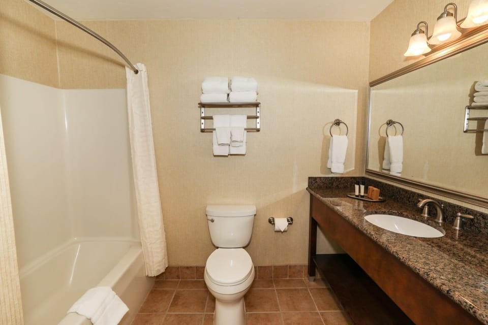 Modern bathroom with a shower/tub combo and a large vanity, providing comfort and convenience.