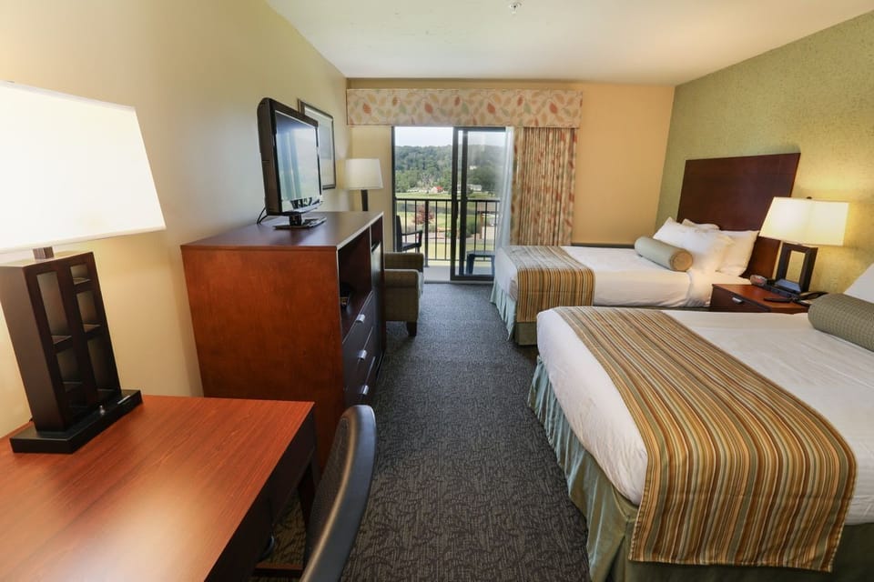 Cozy guest room with a comfortable bed, flat-screen TV, and balcony access for a relaxing stay.