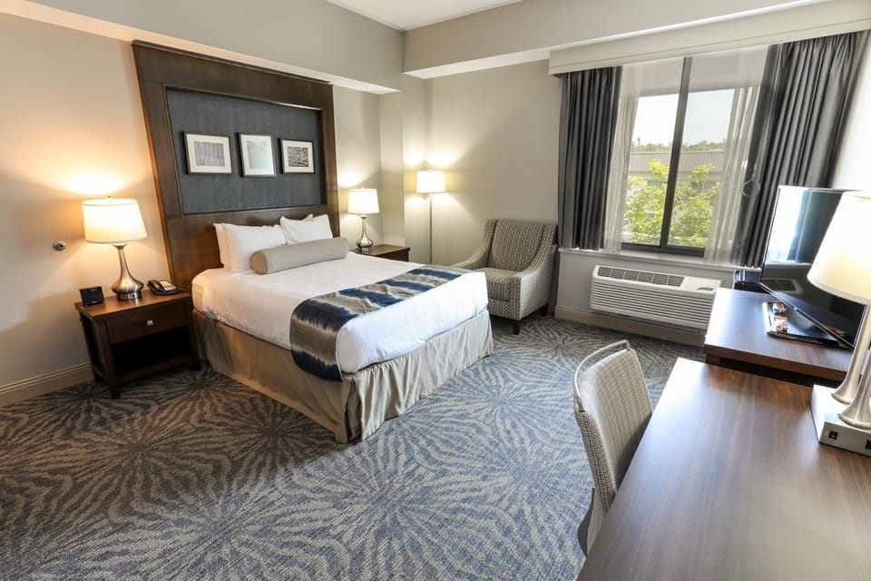 Bright room featuring a cozy bed and a convenient workspace, perfect for both relaxation and productivity.