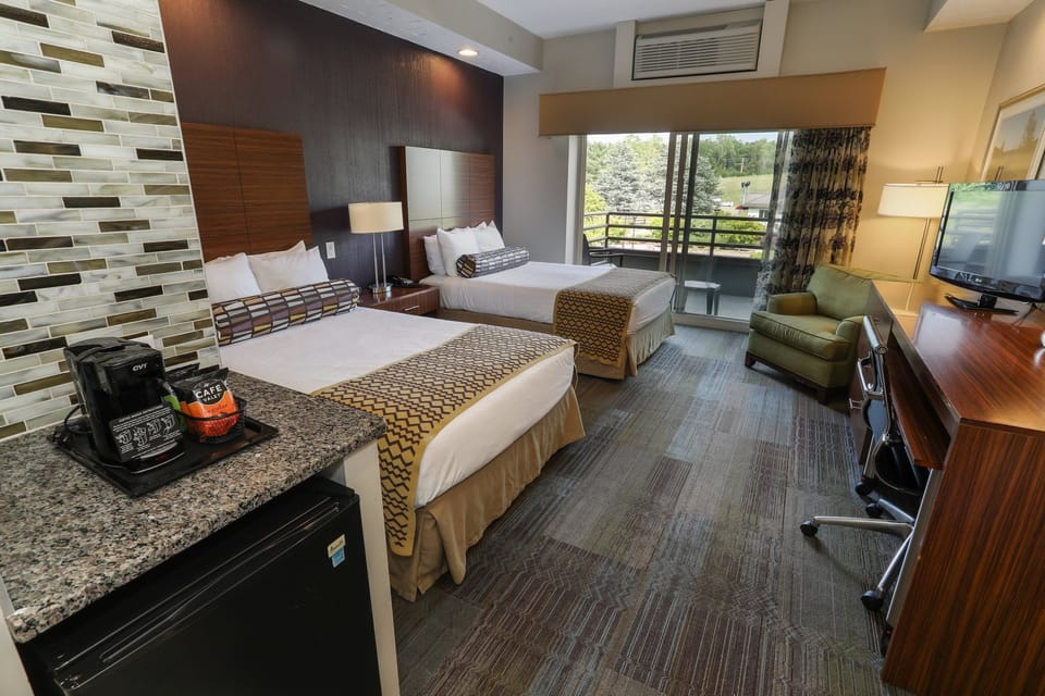 Comfortable room with two plush beds, a modern design, and scenic views through large windows.