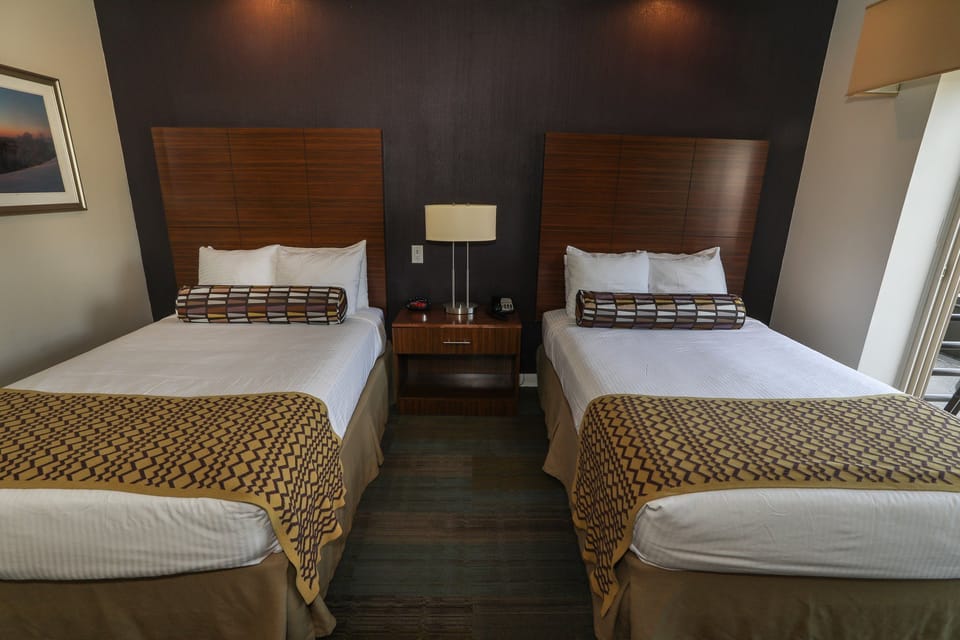 Bright room featuring two plush beds, perfect for a relaxing stay with friends or family.