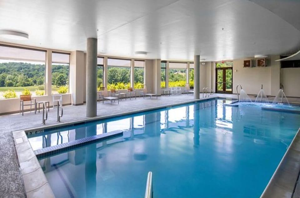 Floor-to-ceiling windows bring the beauty of the outdoors into this serene indoor pool.