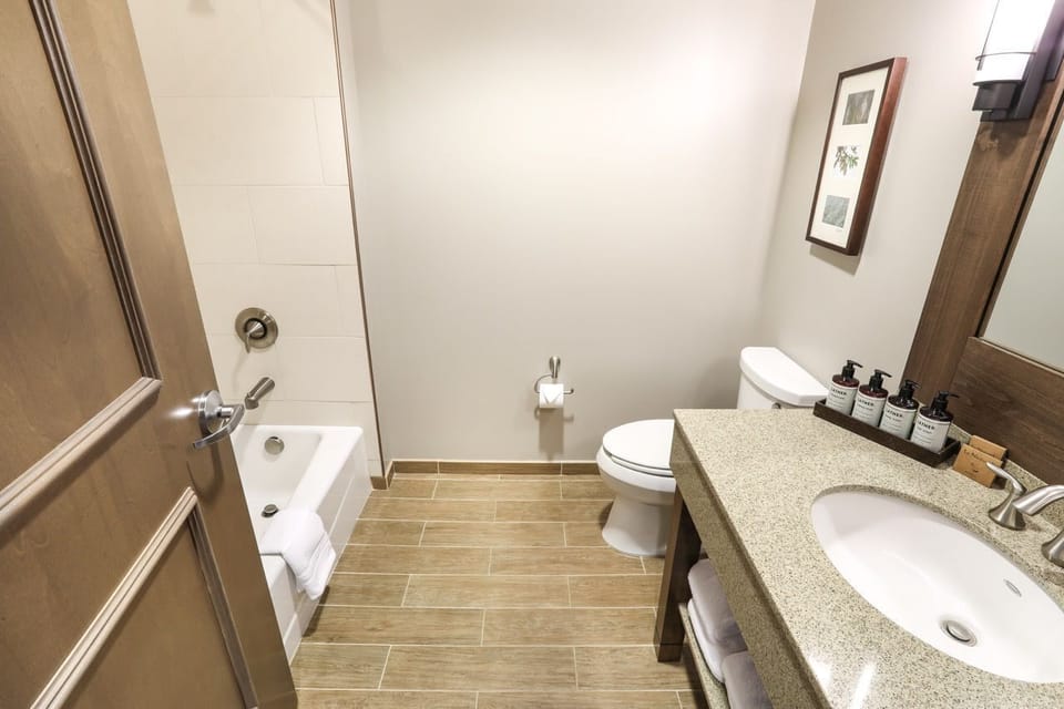 Modern bathroom with a large vanity and shower/tub combo, providing a refreshing experience.
