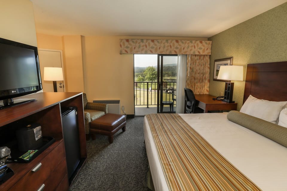Cozy guest room with a comfortable bed, TV, and access to a private balcony.