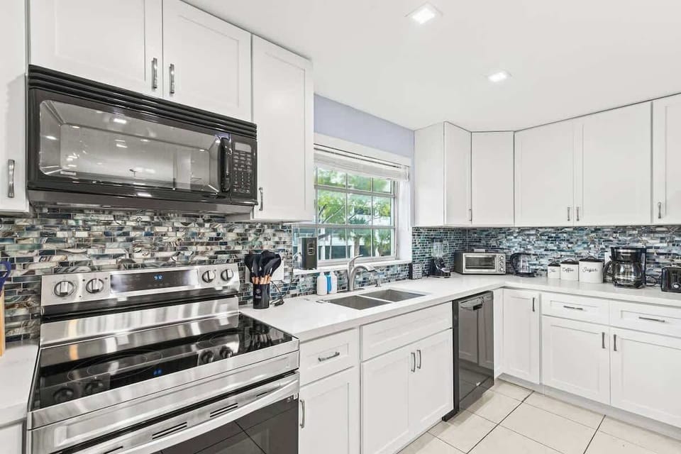 Modern kitchen fully equipped with stainless steel appliances.