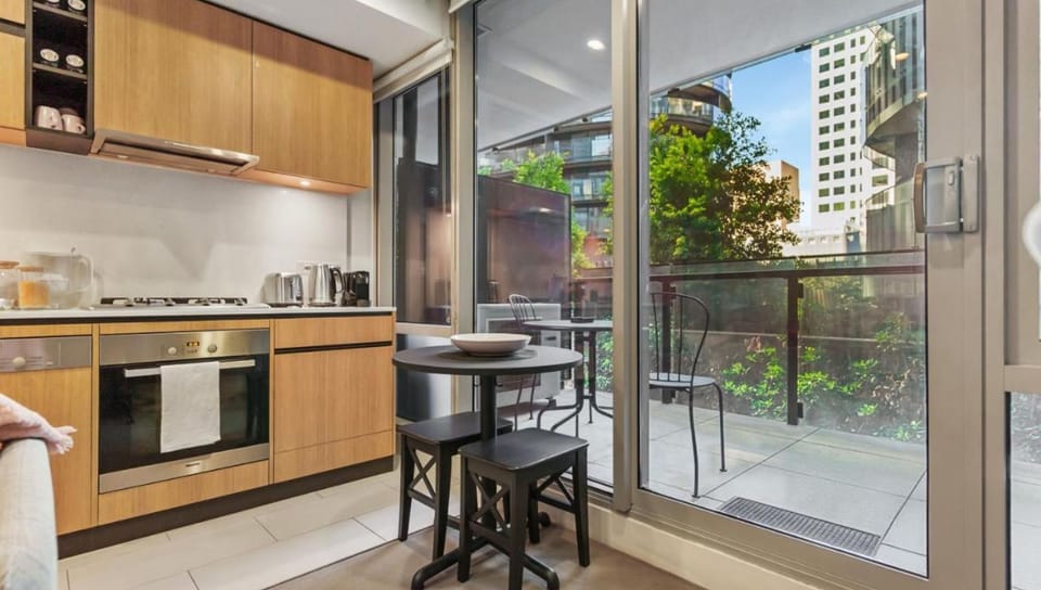 The modern kitchen connects effortlessly to a private balcony space, ideal for al fresco morning coffee.