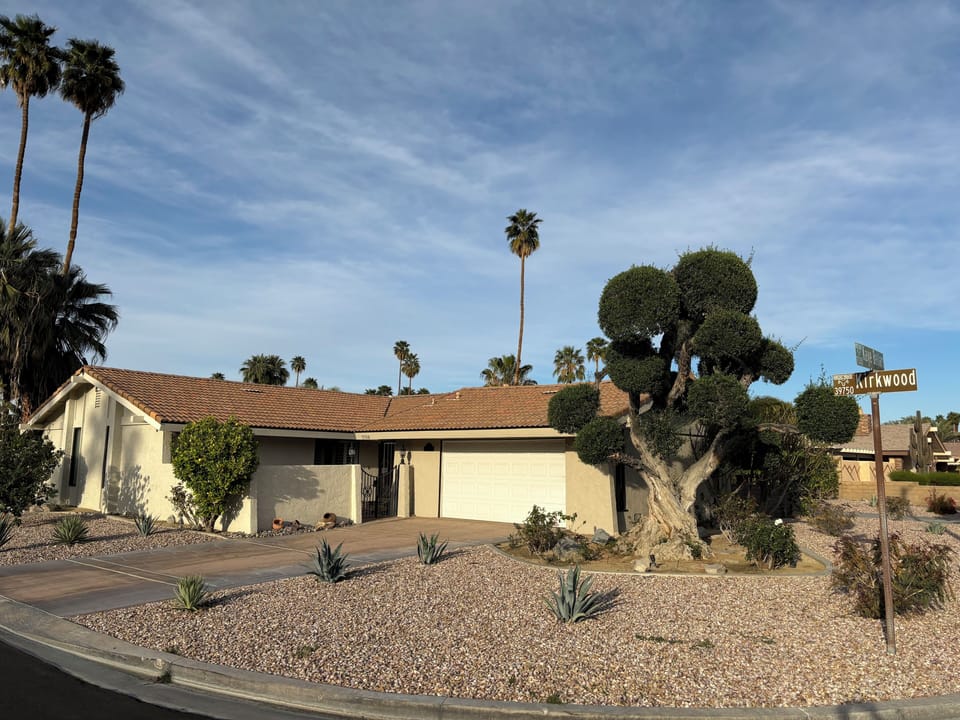 Large corner lot with beautiful trees and plants.