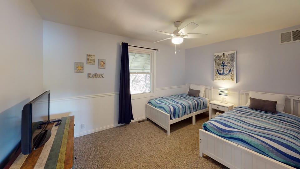 Cozy twin bedroom with a charming nautical theme and lake-inspired décor.