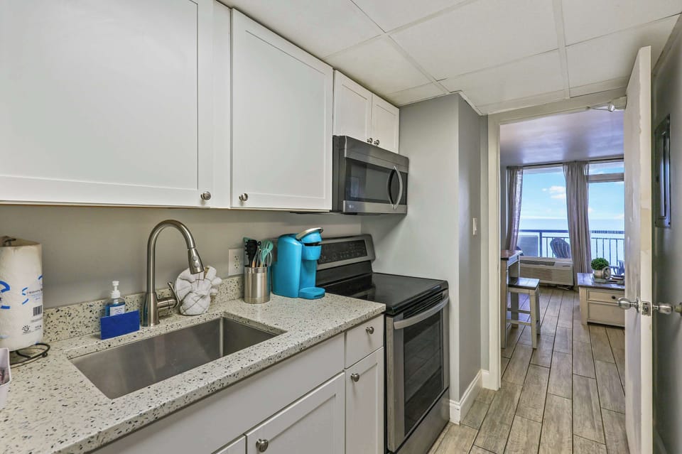 Cook with a view in this fully equipped kitchen featuring modern appliances, granite countertops, and ocean sights just steps away. Perfect for whipping up meals during your Myrtle Beach getaway!