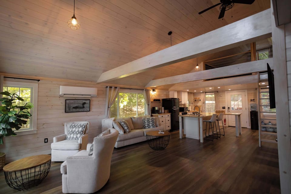 Spacious open-concept living area with vaulted ceilings and a cozy cabin-style feel.