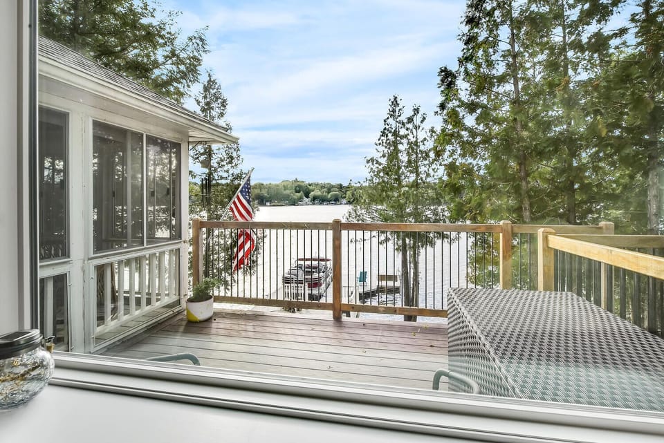 A serene lakeside view from the comfort of Gables End Escape. Step outside and enjoy the fresh air, or relax indoors while taking in the stunning sights of Great Pond.