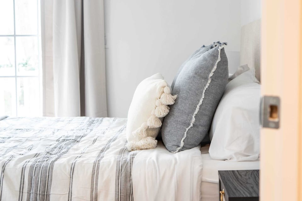 This airy king bedroom includes a comfy armchair & balcony access