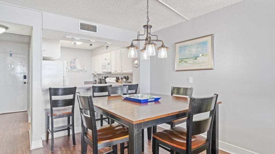 Enjoy meals in this inviting dining space with seating for six and a warm coastal ambiance, perfect for post-beach gatherings.