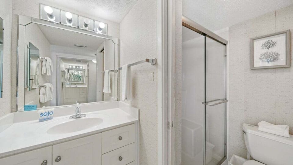 This bathroom offers a spacious walk-in shower, wide vanity with great lighting, and clean finishes for a bright, refreshing space.