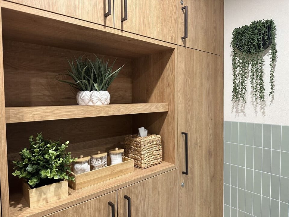 Built-in storage with stylish shelving, greenery, and neatly organized essentials. A functional yet decorative space that adds convenience while enhancing the room’s warm, modern feel.