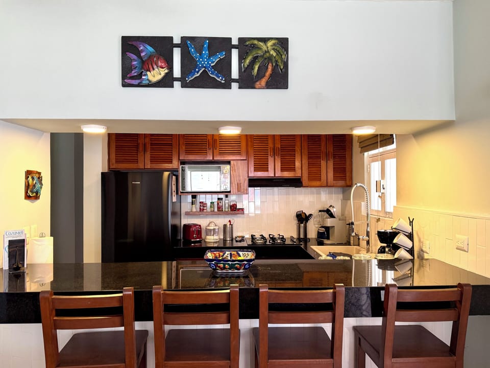 Well-equipped kitchen with full-size refrigerator, microwave, gas cooktop/oven.