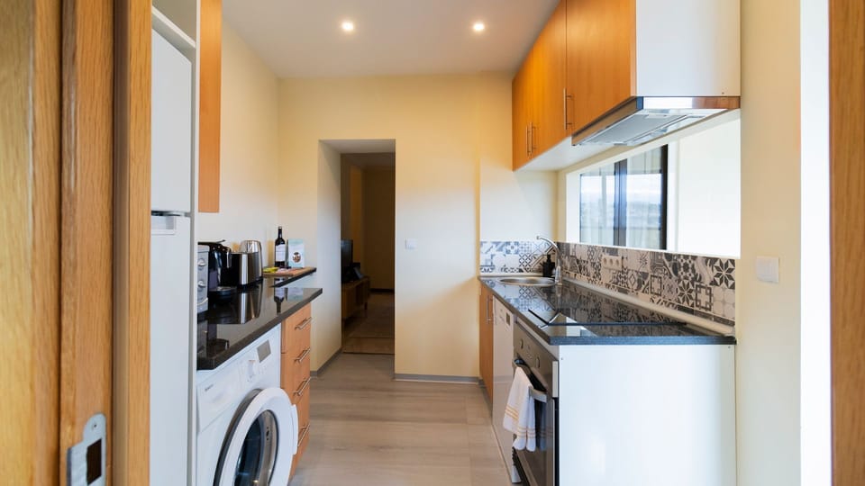 The fully equipped kitchen is perfect for preparing delicious meals, complete with a washing machine to make longer stays effortless. Enjoy the convenience of home cooking and laundry in a bright, functional space.