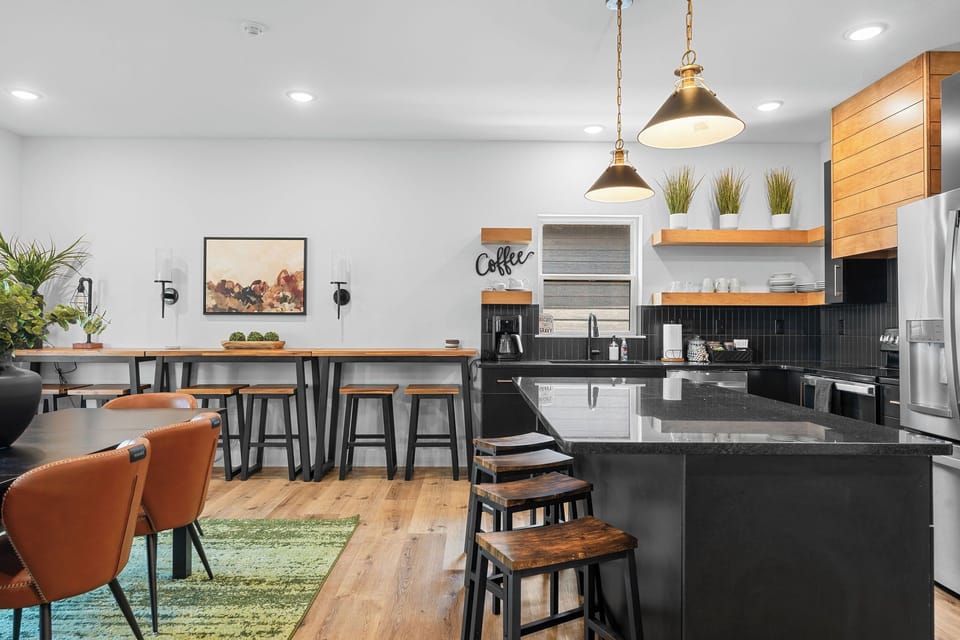 - Spacious dining table perfect for shared meals and game nights
- High-top bar with additional seating and fun “adventure” wall art
- Open-concept design flows effortlessly from kitchen to dining