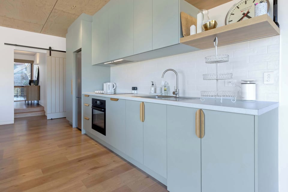 fully equipped kitchen comes with induction cooktop, microwave, dishwasher, and concealed washing machine