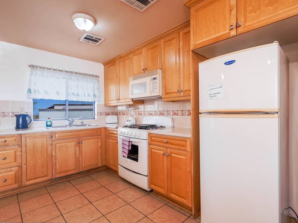 The kitchen comes fully equipped for preparing home-cooked meals, including a refrigerator, oven, microwave, and essential cookware