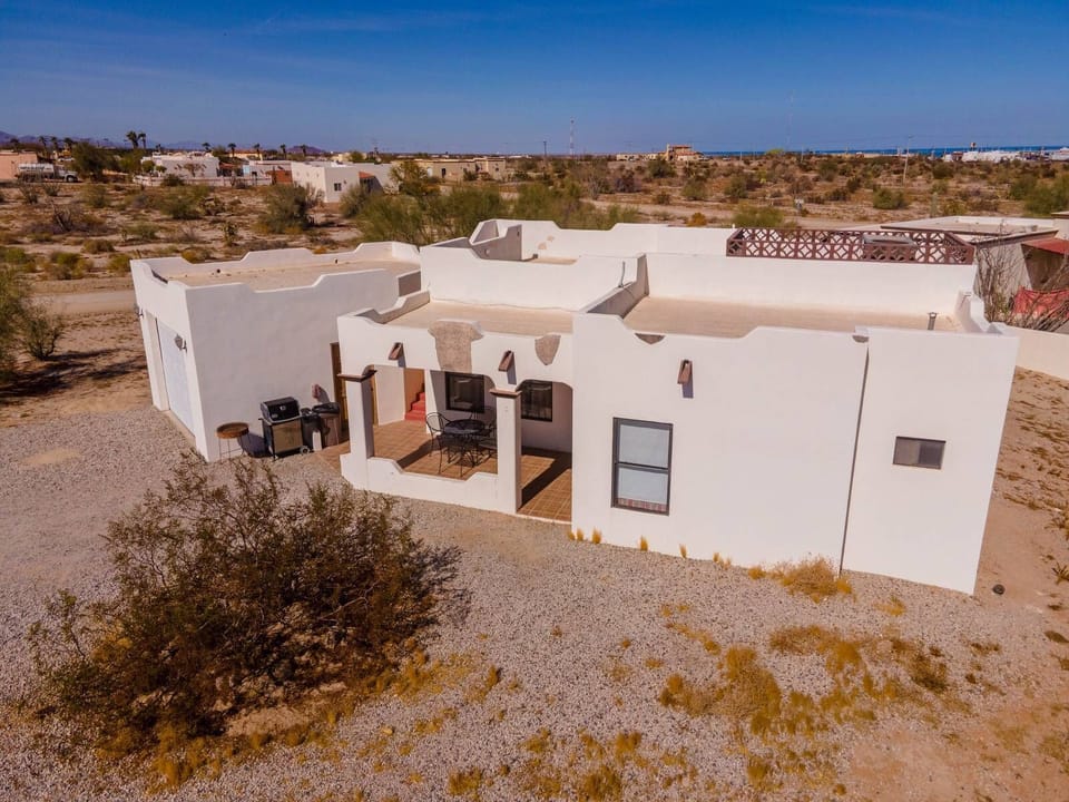 This aerial drone shot shows the front of Casa Tilly, a 2-bedroom, 2-bath home with a fully equipped kitchen, flat-screen TV, and patio with outdoor dining area