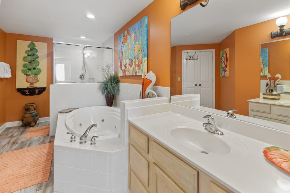 Unwind in your vibrant master bathroom featuring a luxurious jetted tub and dual vanities, perfect for pampering yourself after a day of exploring.