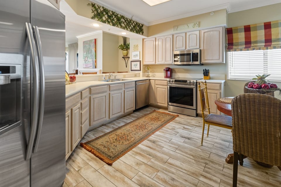 Your fully-equipped kitchen invites culinary adventures with stainless steel appliances, ample counter space, and warm wood cabinetry.