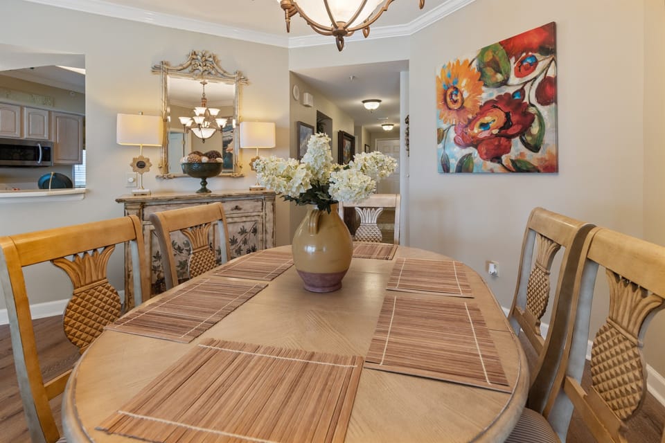 Gather around this elegant dining table where vibrant artwork and warm lighting create the perfect setting for your memorable meals together.