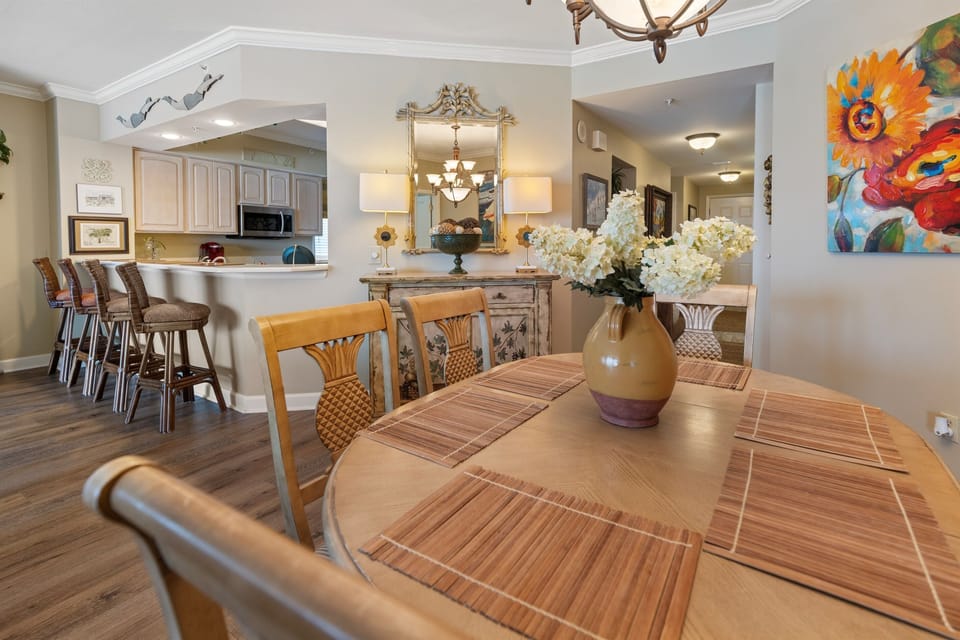 Gather around your elegant dining table where fresh flowers welcome you home after beach days, while the open kitchen invites culinary adventures.