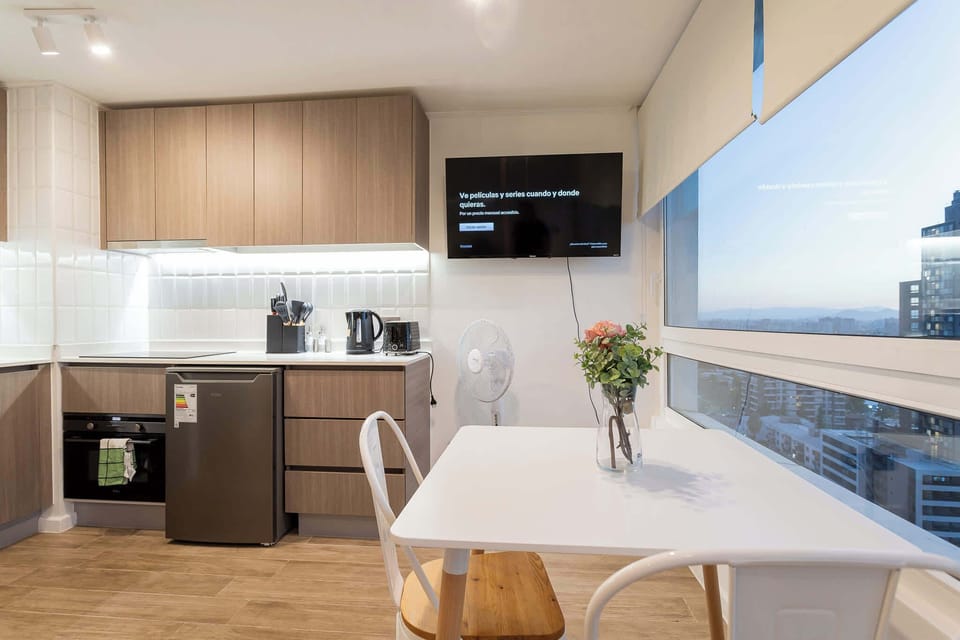 Cozy studio kitchen with modern amenities and stunning city views, perfect for a romantic getaway in the heart of Chile.