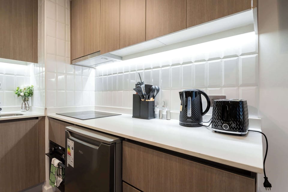 Modern studio kitchen with sleek appliances and stylish design, perfect for cozy cooking experiences.
