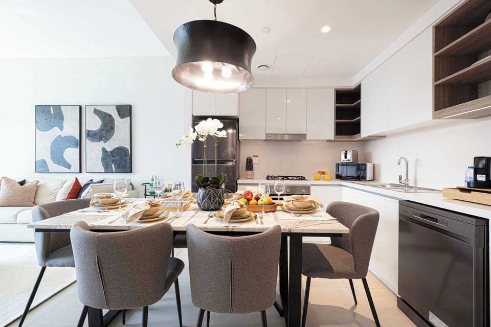 Gather with family and friends around this elegant dining table with six chairs, located next to the living room and fireplace, offering a cozy setting for meals and stunning views of the city skyline.